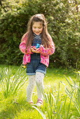 young girl holding Easter eggs outside