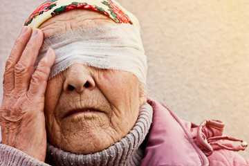 Old grandmother blindfolded close up. A blindfold on the eyes of an old grandmother. Creative photo of a grandmother with a blindfold. Conceptual photo of uncertainty, fears. The psychological state 