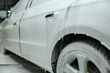 contactless car washing. car covered with foam at a car wash