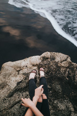 girl on a rock on a black beach