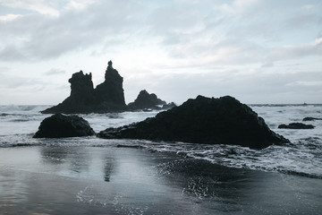 girl on a rock on a black beach