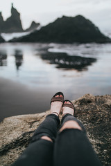 girl on a rock on a black beach
