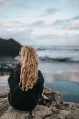 girl on a rock on a black beach