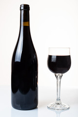 bottle of red wine and glass isolated on a white background