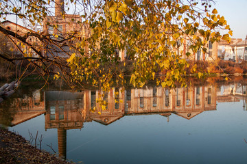 Reflection in the lake of an old factory in autumn 