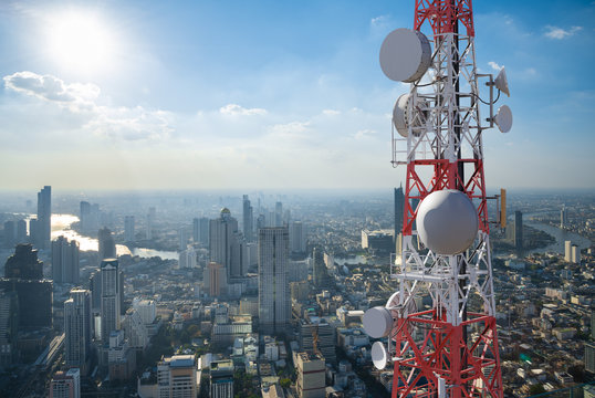 Telecommunication tower with 5G cellular network antenna on city background