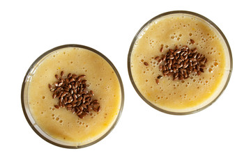 Two glasses with orange-banana smoothie isolated on a white background