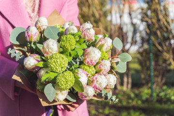 Elegant woman holding beautiful and exotic flower buquet in hands. Ice cream tulips bouquet...