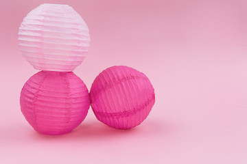 Fototapeta na wymiar pelotas de papel en fondo rosa, decoracion de palpel