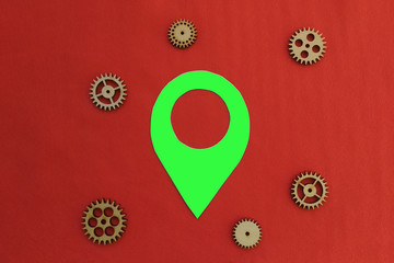 A green geolocation sign surrounded by wooden gears on a red background. Location tracking...
