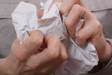 A man's hands crumple the paper. Concept bad idea, failure, cancellation, dismissal, termination of the contract.