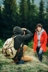 tourist photographer is taking photos of a woman in the forest