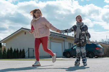 Mother and son riding roller skates on a sunny day together. Happy family concept.