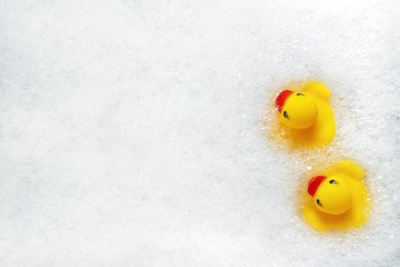 High Angle View of yellow rubber duck in bath swimming in foam water. Yellow rubber ducklings in soapy foam.