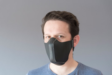 Portrait of a young man wearing a homemade synthetic leather face mask