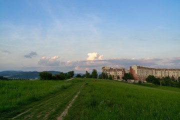 Fototapeta na wymiar Sunrise and sunset, beautiful clouds over the meadow, hills and buildings in the town. Slovakia