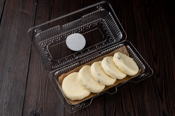 Semi-finished cottage cheese patties in a plastic delivery box