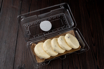Semi-finished cottage cheese patties in a plastic delivery box