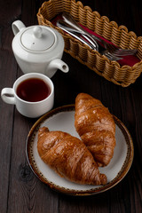 Baked fluffy croissants with golden crispy crust on wooden table, top view