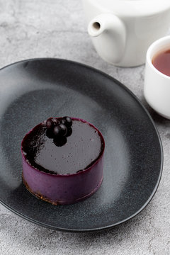 Mirror glazed blueberry mousse cake on black minimalist plate