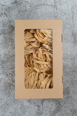 Handmade tagliatelle nests in a cardboard delivery box
