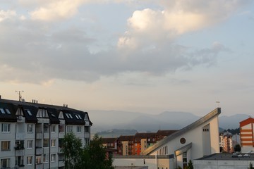 Sunrise and sunset, beautiful clouds over the meadow, hills and buildings in the town. Slovakia