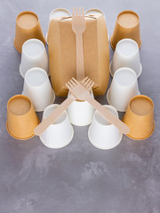 Zero waste. Disposable tableware. Eco-friendly disposable utensils made of bamboo wood and paper on a gray background. Paper cups, fast food containers and bamboo wooden cutlery