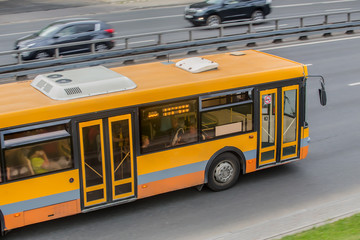 Fototapeta na wymiar City Bus Moves along the Highway