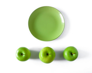 Fresh green apple with green plate on white background.