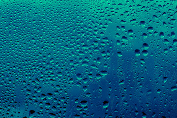 Blue and green raindrops on the glass