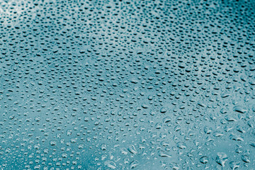 Blue and green raindrops on the glass
