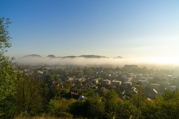 Sunrise and sunset, beautiful clouds over the meadow, hills and buildings in the town. Slovakia