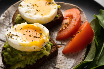 Sandwich with guacamole made of ripe avocados and poached egg. Healthy diet or vegetarian food  