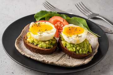 Sandwich with guacamole made of ripe avocados and poached egg. Healthy diet or vegetarian food  