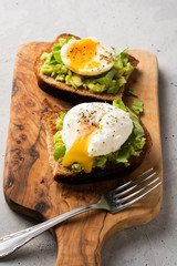 Sandwich with guacamole made of ripe avocados and poached egg. Healthy diet or vegetarian food  