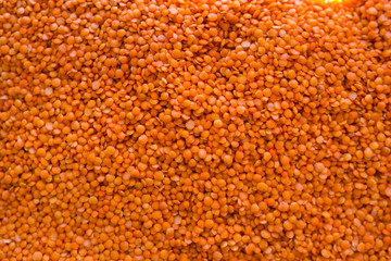 Red lentils strewn in a crate in a store