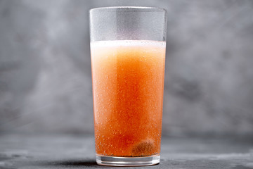 Effervescent vitamin C tablet bubbles in glass of water