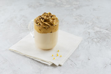 Dalgona coffee in a glass mug: whipped coffee with milk.