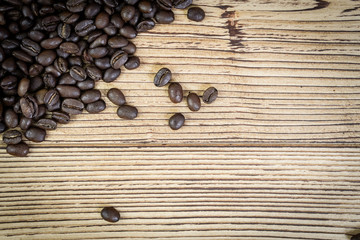 Fresh coffee beans on  wooden table background.