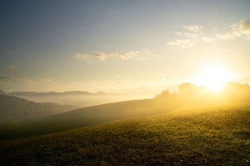 Sunrise and sunset, beautiful clouds over the meadow, hills and buildings in the town. Slovakia