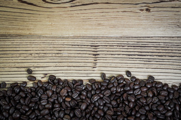 Fresh coffee beans on  wooden table background.