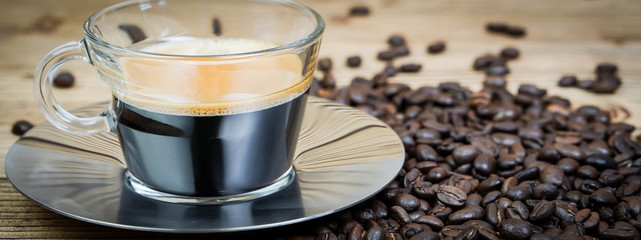 Banner cup of coffee and coffee beans on wooden  background.