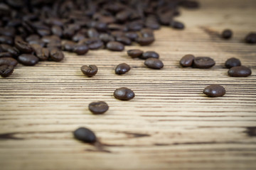 Fresh coffee beans on  wooden table background.