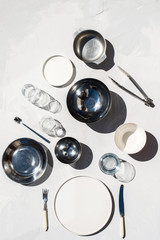  Photo of a metal bowl, porcelain plate and kitchenware stuff and glass for cooking on white background sunlight