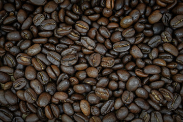 Fresh coffee beans on  wooden table background.