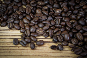 Fresh coffee beans on  wooden table background.