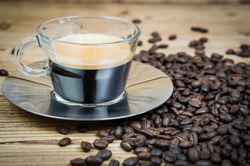 Cup of coffee and coffee beans on wooden  background.