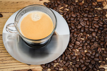 Cup of coffee and coffee beans on wooden  background.