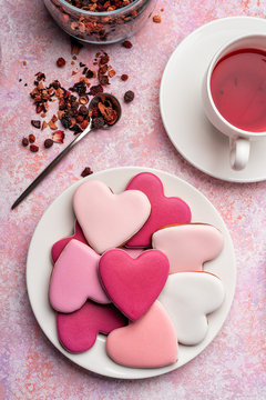 Heart shape cookies with icing with berry tea. Concept: Valentine's Day tea party, festive table setting in pink.