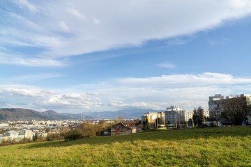 Sunrise and sunset, beautiful clouds over the meadow, hills and buildings in the town. Slovakia